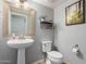 Neutral half bath showcasing a pedestal sink, decorative mirror, and tiled floors for a simple yet functional design at 2435 N Riley Rd, Buckeye, AZ 85396