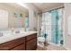 Bright bathroom featuring a vanity with a sink, toilet, and a shower with nautical themed curtain at 2435 N Riley Rd, Buckeye, AZ 85396