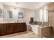 Modern bathroom features double sinks, a soaking tub, and a separate glass-enclosed shower, creating a spa-like experience at 2435 N Riley Rd, Buckeye, AZ 85396