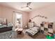 Pink Bedroom with a rocking chair, crib and plush toys, providing a sweet and calming environment for your little one at 2435 N Riley Rd, Buckeye, AZ 85396