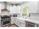 Bright kitchen features white cabinets, stainless steel appliances, farmhouse sink, and a large window at 2435 N Riley Rd, Buckeye, AZ 85396
