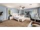 Spacious main bedroom featuring a ceiling fan, an aquarium, and neutral carpet, offering relaxation and versatility at 2435 N Riley Rd, Buckeye, AZ 85396