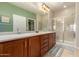 Bathroom featuring double sinks, granite countertops, and a glass enclosed shower at 26270 W Horsham Ct, Buckeye, AZ 85396