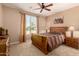 Bedroom showcasing a wood frame bed, soft lighting, and a large window at 26270 W Horsham Ct, Buckeye, AZ 85396