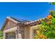 Beautiful home exterior shows solar panels, brick and stucco, and colorful orange flowers at 26270 W Horsham Ct, Buckeye, AZ 85396