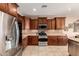 Well-lit kitchen featuring stainless steel appliances, granite countertops, and custom wood cabinetry at 26270 W Horsham Ct, Buckeye, AZ 85396