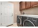 Laundry room equipped with a modern washer and dryer, with ample cabinet space for storage at 26270 W Horsham Ct, Buckeye, AZ 85396