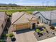 Aerial view of a well-maintained home featuring tile roofing, a paver driveway, lush landscaping, and a view of the golf course at 26421 W Zachary Dr, Buckeye, AZ 85396