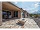 Covered backyard patio with stone floors and a central fire pit, perfect for entertaining at 26421 W Zachary Dr, Buckeye, AZ 85396