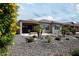 Lovely single-story home featuring desert landscaping with blooming yellow flowers and a covered patio, creating a serene outdoor space at 26421 W Zachary Dr, Buckeye, AZ 85396
