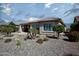 Charming single-story home showcasing desert landscaping with palm trees, cacti, and a covered patio, ideal for enjoying the outdoors at 26421 W Zachary Dr, Buckeye, AZ 85396