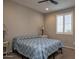 Cozy bedroom featuring neutral walls, shuttered window, and a bed with a blue and white patterned comforter at 26421 W Zachary Dr, Buckeye, AZ 85396