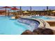 Stunning community pool area with a water slide, sun loungers, and lush landscaping at 26421 W Zachary Dr, Buckeye, AZ 85396