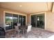 Relaxing covered patio has a dining table with four chairs, offering a perfect outdoor living space with views of the golf course at 26421 W Zachary Dr, Buckeye, AZ 85396