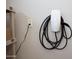 Wall-mounted Tesla charging station next to a storage rack in the garage at 26421 W Zachary Dr, Buckeye, AZ 85396