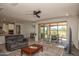 Open-concept living room with golf course views and sliding glass doors to outdoor patio at 26421 W Zachary Dr, Buckeye, AZ 85396