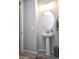 This powder room features a decorative mirror, a pedestal sink, and a towel rack at 26421 W Zachary Dr, Buckeye, AZ 85396