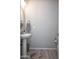 The powder room features a decorative mirror, a pedestal sink and wood-look tile floors at 26421 W Zachary Dr, Buckeye, AZ 85396