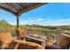Relaxing covered patio area with comfortable seating and a fire pit, overlooking a beautiful landscape at 29308 N 108Th N Pl, Scottsdale, AZ 85262