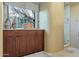 Bathroom with wooden cabinets, granite countertops, and view from the window at 29308 N 108Th N Pl, Scottsdale, AZ 85262