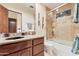 Elegant bathroom featuring a granite vanity, tiled shower with glass door, and warm lighting at 29308 N 108Th N Pl, Scottsdale, AZ 85262