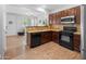 Open kitchen view featuring granite countertops, stainless steel microwave, and wood-look flooring at 2941 N Evergreen St, Buckeye, AZ 85396