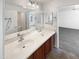 Bright bathroom featuring double sinks, tiled floor, large mirror and access to another room at 30271 W Crittenden Ln, Buckeye, AZ 85396
