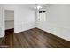 Bedroom with hardwood floors, white trim, a ceiling fan, a window, and a walk-in closet at 30271 W Crittenden Ln, Buckeye, AZ 85396