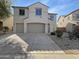 Two-story home featuring a three-car garage, neutral stucco, and desert landscaping in front at 30271 W Crittenden Ln, Buckeye, AZ 85396