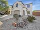 Inviting home featuring desert landscaping, a stone creek bed, and a three car garage at 30271 W Crittenden Ln, Buckeye, AZ 85396