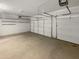 Spacious three-car garage featuring white walls, smooth concrete floor, and ceiling mounted garage door openers at 30271 W Crittenden Ln, Buckeye, AZ 85396