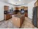 A spacious kitchen featuring wood cabinets, granite countertops, stainless steel appliances, and tile flooring at 30271 W Crittenden Ln, Buckeye, AZ 85396