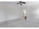Main bedroom with neutral carpet, a ceiling fan, bright white walls, an arched entrance to an en-suite bathroom at 3531 N Sericin --, Mesa, AZ 85215