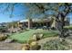 Expansive home exterior featuring a putting green, outdoor patio, desert landscaping, and panoramic views at 41611 N 113Th Pl, Scottsdale, AZ 85262