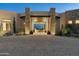 Striking front exterior with stone accents, desert landscaping, and paver driveway creates inviting curb appeal at 41611 N 113Th Pl, Scottsdale, AZ 85262