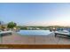 Relaxing infinity pool with lounge chairs, fire pits, and breathtaking views of the lake and golf course at 41611 N 113Th Pl, Scottsdale, AZ 85262