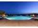 Inviting infinity pool with views of golf course and fire pits at night at 41611 N 113Th Pl, Scottsdale, AZ 85262