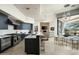 Open kitchen featuring stainless steel appliances, a center island with seating, and seamless flow to the living area at 41611 N 113Th Pl, Scottsdale, AZ 85262