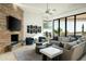 Relaxing living room featuring a stone fireplace, comfortable seating, and a beautiful view of the backyard at 41611 N 113Th Pl, Scottsdale, AZ 85262