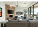 Bright living room featuring a stone fireplace, comfortable seating, and large windows for ample natural light at 41611 N 113Th Pl, Scottsdale, AZ 85262