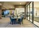 Charming outdoor dining area on a covered patio with views of the home's interior through large glass windows at 41611 N 113Th Pl, Scottsdale, AZ 85262