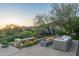 Cozy outdoor patio with a modern fire pit and comfortable seating, surrounded by lush greenery at 41611 N 113Th Pl, Scottsdale, AZ 85262