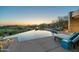 Stunning infinity pool overlooks the scenic desert landscape at sunset, offering a luxurious outdoor experience at 41611 N 113Th Pl, Scottsdale, AZ 85262