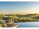 Stunning infinity pool overlooking the lush green golf course with mature trees and desert landscape at 41611 N 113Th Pl, Scottsdale, AZ 85262