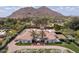 Aerial view of the property showcasing beautiful landscaping, a sprawling home, a circular driveway, and mountain views at 5220 N Casa Blanca Dr, Paradise Valley, AZ 85253