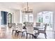 The dining room features a decorative chandelier, neutral color scheme, and access to the outdoor terrace through French doors at 5220 N Casa Blanca Dr, Paradise Valley, AZ 85253