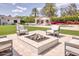 Relaxing outdoor patio area featuring a gas fire pit with cushioned chairs, set against a backdrop of lush landscaping at 5220 N Casa Blanca Dr, Paradise Valley, AZ 85253
