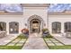 Stately home entrance with a manicured walkway, terracotta roof, and beautiful flower arrangements at 5220 N Casa Blanca Dr, Paradise Valley, AZ 85253