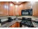 Close up of kitchen features: wooden cabinets, granite counters, and stainless steel appliances at 5450 E Deer Valley Dr # 1201, Phoenix, AZ 85054