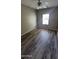 Cozy bedroom featuring wood-look laminate floors, neutral walls, and a window providing natural light at 5734 W Gwen St, Laveen, AZ 85339